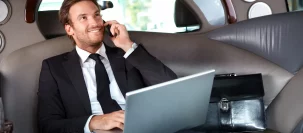 man talking on phone while sitting in black car